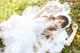 A woman in a white dress laying on the ground.