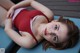 A woman in a red bathing suit laying on a blue bench.