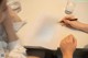 A woman sitting at a table writing on a piece of paper.