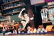 A woman in a black lingerie sitting at a bar.