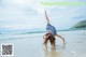 A woman doing a handstand on the beach. 