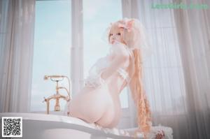 A woman in a wedding dress sitting in a bathtub.