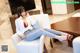 A woman sitting on a white chair in a living room.