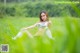 A woman sitting in a field of green grass.